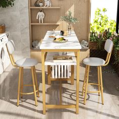 a kitchen table with two chairs and an oven in the back ground, next to a washer and dryer