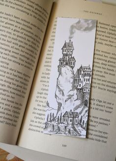 an open book with a drawing of a castle on top of it and the pages are black and white