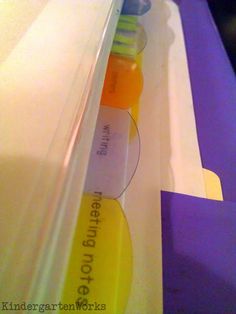 an orange and yellow toothbrush sitting on top of a purple box with writing underneath it