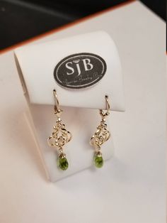 "Bright green Peridot faceted briolette dangle earrings. Set in 14kt Yellow Gold bell caps, with scallop-edged decorative details and large symeterical filigree dangle all hanging from a fleur-de-lis leverbacks. Measures approximately 2\" long. August Birthstone. Pantone Green 2017 color of the year. Please feel free to contact me anytime, if you have any questions or need any additional information. All items are available for local pickup. Contact me for your \"free shipping\" coupon code befo Yellow Gold Peridot Earrings For Gift, Gold Peridot Earrings Fine Jewelry, Green 14k Gold Dangle Earrings, 14k Gold Green Pierced Earrings, Peridot Dangle Earrings In Gold, Fine Jewelry With Peridot And Matching Earrings, Elegant Pierced Peridot Jewelry, Formal Peridot Drop Earrings, Elegant Peridot Birthstone Earrings