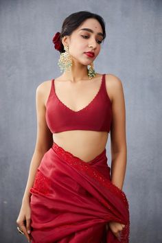 "We Crafts Designer Blouse/Crop Top, Designer Bollywood Saree, Banarasi Silk Saree, Designer Wedding Lehengas, Bridal Lehenga, South Indian Dresses, Chaniya Choli, Bridesmaid Lehengas, Sabyasachi Lehengas, Floral Skirts, Punjabi Suits, Indo-western Outfits Etc. ABOUT Red saree blouse with placement bead embellishments & tassel tie-up back. Components:1 Embroidered Neckline:V Neck Sleeve Length:Sleeveless Fabric:Handwoven Chanderi Color:Red Tassel tie-up back Plunging neck * Color & Sleeves can b Red Saree Blouse, Sleeveless Blouse Designs, Saree Blouses Online, Blouse Neck, Red Saree, Trendy Blouses, Trendy Blouse Designs, Stylish Sarees, Blouse For Women