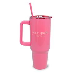 a pink travel mug with a straw in the handle and name kate spade new york on it