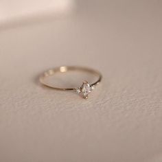 a diamond ring sitting on top of a white surface