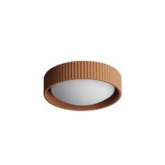 a round light fixture on a white wall with a brown stripe around the top and bottom