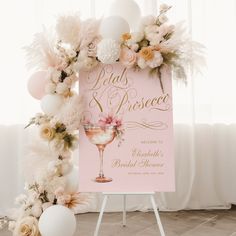 a pink sign with flowers and balloons on it next to a white table cloth banner