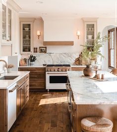 a kitchen with wooden floors and marble counter tops, along with an oven in the center