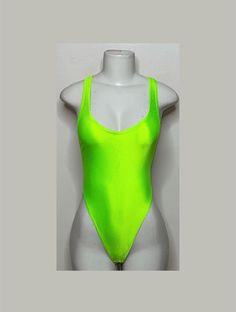 Welcome to my shop Let's Make Money Together 💕 DETAILS  * Handmade Item  * Materials: Nylon, Spandex * Full Bodysuit  * Never used  DESCRIPTION  * Thong Bodysuit  * Neon Green Shiny Spandex * 4 way stretch Fabric  * Mannequin is wearing  XS/Small (may choose sizing at checkout) SHIPPING  My current shipping turnaround is really quick 1 to 2 days  RETURNS & EXCHANGES  No refunds or exchanges if you have any issues with your purchase please feel free to reach me personally. I can accommodate on y High Stretch Summer Club Leotard, Summer Dance Bodysuit With High Stretch, Summer Dance Bodysuit With Stretch, High Stretch Bodysuit For Summer Dance, Summer Club T-back Bodysuit, Summer Dancewear Bodysuit For Dance, Summer T-back Bodysuit For Club, Summer One-piece Club Leotard, Stretch T-back Leotard For Party