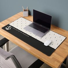 a laptop computer sitting on top of a wooden desk next to a white mouse pad