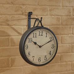 a clock hanging from the side of a brick wall