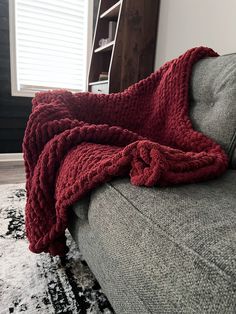 a couch with a blanket on top of it and a rug in front of it