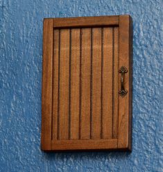 a wooden door on the side of a blue wall with a keyhole in it