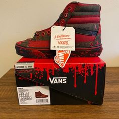 a pair of red and black vans shoes sitting on top of a box