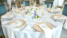 the table is set with silverware and white linens for an elegant wedding reception