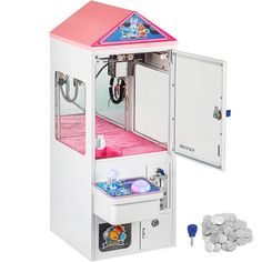 a small toy machine with lots of coins in front of it and the door open