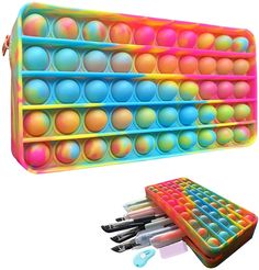 an assortment of pens and pencils in a multicolored case with dividers