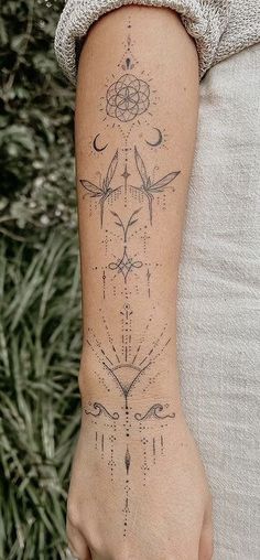 a woman's arm with tattoos on it, and an arrow in the middle