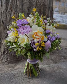 a bouquet of flowers sitting next to a tree