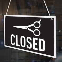 a closed sign hanging from the side of a glass door that says, closed with scissors on it