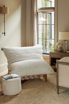 a white bed sitting next to a window in a bedroom