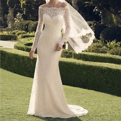 a woman in a wedding dress with a veil on her head and an open shoulder