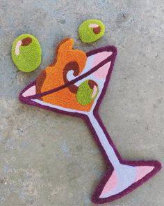 an odd looking object made out of felt with fruit on the ground next to it