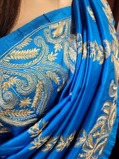 There are two colors 1. Deep Sky Blue 2. Royal Blue This is an authentic hand-embroidered Ari Kashmiri Stitch Saree from Murshidabad district in Bengal. Our skilled artisans entirely handcraft the fine embroidery design. The most significant aspect of hand embroidery is the running stitch pattern that accentuates the various motifs. The running blouse piece is included with this silk saree. Saree Length : 5.5 meters Blouse Piece Length : 0.8 meters Design : Hand Ari Kashmiri embroidery Fabric : Pure Bangalore Silk -- Silk Mark Certified. Color :  Blue Washing : Dry Clean Get this exclusive Hand Embroidered Kantha Saree online at Rainbow Boutique - The best online store for pure silk saree, tussar silk saree. Blue Embroidered Fabric With Dori Work For Navratri, Katan Silk Saree With Intricate Embroidery, Blue Embroidered Dori Work Fabric For Festive Occasions, Blue Embroidered Fabric With Dori Work For Festive Occasions, Festive Blue Embroidered Fabric With Dori Work, Blue Chikankari Embroidery Blouse For Navratri, Blue Embroidered Fabric With Dori Work For Festivals, Blue Blouse With Chikankari Embroidery For Navratri, Traditional Royal Blue Kurta With Pallu