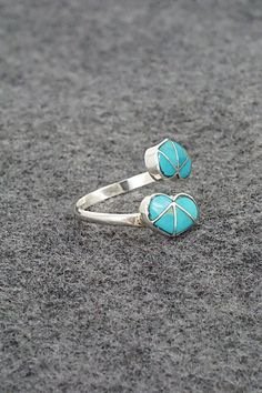 This turquoise and sterling silver heart-shaped ring was made by Zuni silversmith Gina Dosedo.Size: 8, adjustableLength: 5/8"Width: 3/8"Free shipping on all orders! We ship with USPS and always include tracking. All orders ship within a day of payment.Returns are accepted up to 30 days after you receive your order. Just send us a message. Our shop offers cash back or store credit. The item must be returned in new condition. Adjustable Nickel-free Sterling Silver Heart Ring, Adjustable Sterling Silver Toe Ring With Heart Design, Adjustable Sterling Silver Heart Toe Ring, Adjustable Heart Shaped 925 Stamped Jewelry, Unique Adjustable Heart Shaped Ring, Unique Adjustable Heart-shaped Ring, Unique Adjustable Heart Ring, Adjustable Turquoise Ring With Inlay For Gift, Adjustable Blue Turquoise Toe Ring