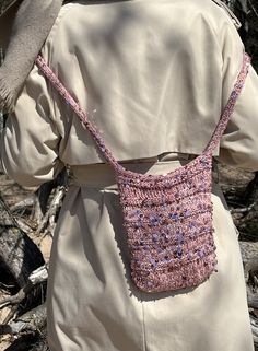 the back of a woman's jacket with a crocheted purse on it