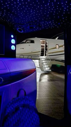 an airplane is parked in the dark with its door open and stairs lit up at night