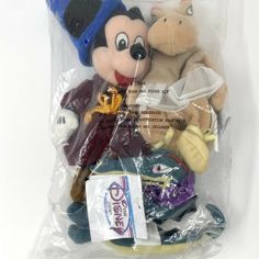 there is a plastic bag with stuffed animals in it that are wrapped up to look like mickey mouse