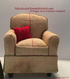 a small chair with a red pillow on it