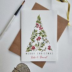 a card with a christmas tree on it next to some other cards and a brush