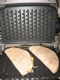 two burritos are being cooked on an electric grill