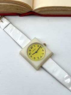 Case Size: 37.6mm Wrist Size: Adjustable Color: Yellow Dial, White Band Material: Acrylic Case, Synthetic Band Movement: Mechanical, Hand-Wind Condition: Vintage, Running and Keeping Time, Some cosmetic imperfections on crystal This unique Endura watch from the 1970s showcases a bold square acrylic case paired with a vibrant yellow dial, perfect for adding a pop of color to any outfit. The white synthetic band is adjustable, ensuring a comfortable fit for both women and unisex wearers. This mech Vintage Rectangular Analog Watches, Vintage Rectangular Analog Watch, Vintage White Watch Accessories With Round Dial, Vintage White Round Dial Watch Accessories, Vintage White Analog Watch, Retro White Watches For Formal Occasions, White Retro Watch For Formal Occasions, White Retro Formal Watch, White Retro Formal Watches