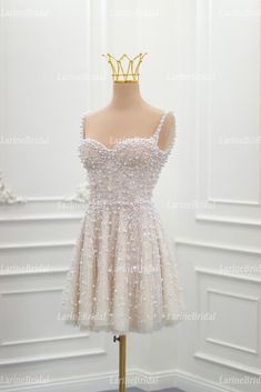 a short white dress on a mannequin stand in front of a white wall