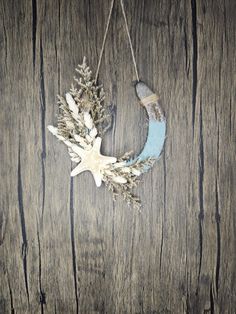 a white and blue wreath hanging on a wooden wall with snow flakes attached to it