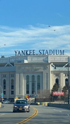 the yankee stadium sign is on top of an old building with cars driving in front