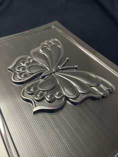 an intricately designed metal box on a black background with the lid open and closed