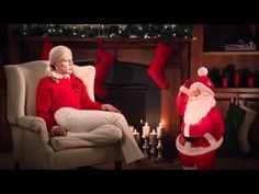 an older woman sitting in a chair next to a santa clause christmas stocking man