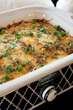 a casserole dish with meat, cheese and green onions