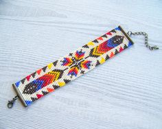 a colorful beaded keychain on a wooden table with a chain attached to it