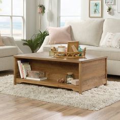 a living room with white couches and wooden coffee table in front of large windows