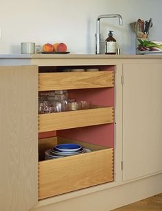 an open cabinet in a kitchen with plates and bowls