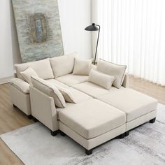 a living room with a large sectional couch and white rug on top of the floor