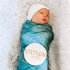 a newborn baby wrapped in a blue blanket with the name stetson on it