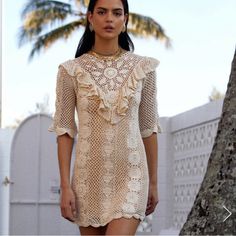 “This Is A Crochet Work Of Art - The Perfect Modern Version Of Classic Gos Elegance. It's The Tiny Artisan Details That Bring This Beautiful Blouse To Life - The Sun, Diamond + Flower Motifs, The Feminine Scalloped Hem, And The V Yoke Frill! This One Is Also Reversible, Making For Multi-Option Styling - Wear The Buttons To The Front, Or To The Back (Or Totally Open!). This Is Such A Cool + Cosy Little Crochet Piece In Our Favourite Classic Cream That Looks Amazing On Everyone. It Adds Exquisite Beige Half Sleeve Beach Dress, Beige Half-sleeve Summer Dress, Bohemian Beige Half Sleeve Dress, Beige Half Sleeve Summer Dress, Feminine Fitted Mini Crochet Dress, Bohemian White Half Sleeve Dress, Beige Fitted Half Sleeve Dress, Beige Fitted Dress With Half Sleeves, White Fitted Crochet Dress With Ruffles