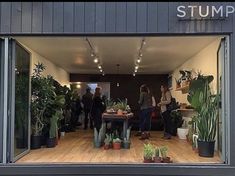 a group of people standing inside of a plant shop