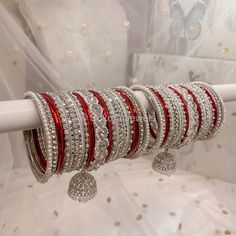 Large stack of luxurious Silver & clear stonework bangles with Maroon shades finished with our Chunky Silver Husna Jhumka bangles. This will make the perfect stack for any Bride or those wanting to make a statement. Pair this with our Aafiya Bridal Set  Sold as a set for both arms only. Ready to Ship! Bollywood Style Silver Jeweled Bracelets, Festive Silver Jeweled Bangle, Red Crystal Bracelet For Wedding, Silver Bollywood Bangle For Party, White Bollywood Bracelet With Stone Work, White Bracelet With Stone Work For Celebration, Silver Stackable Crystal Bracelet For Wedding, Heavy White Bracelets For Festive Occasions, Stackable Silver Crystal Bracelet For Wedding