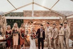 a group of people standing next to each other in front of a brick wall and ceiling