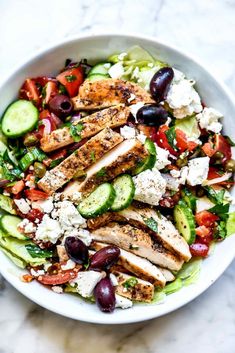 a salad with chicken, cucumbers, olives and feta cheese